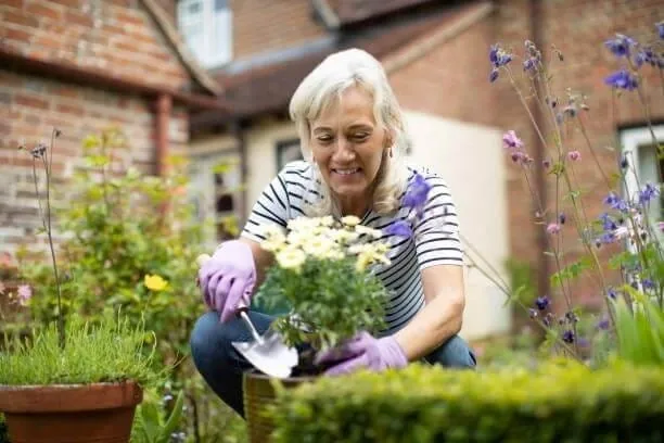 An older woman gardening in sturdy shoes